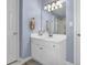 Bathroom vanity area featuring white cabinets, brushed gold hardware, and a framed mirror at 361 Fountainmist Trl, Lawrenceville, GA 30043