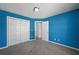 Bedroom featuring blue walls, carpeted floor, and a double door closet at 6279 Nellie Se Br, Mableton, GA 30126