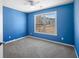 Cozy bedroom with blue walls, plush carpet, and a bright window offering natural light at 6279 Nellie Se Br, Mableton, GA 30126