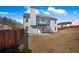 Exterior shot showcasing home's back with gray siding, balcony, and a large, fenced backyard space at 6279 Nellie Se Br, Mableton, GA 30126