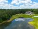 Aerial view of a large home, pond, sports court, and surrounding greenery at 535 Waters Way, Fayetteville, GA 30215