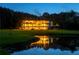 Luxury home reflected in a tranquil pond, featuring a vast lawn and elegant lighting at 535 Waters Way, Fayetteville, GA 30215