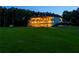 Three-story estate with multiple balconies overlooking a sprawling green lawn, beautifully lit at dusk at 535 Waters Way, Fayetteville, GA 30215