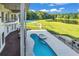 An inviting outdoor space showcasing a pool, hot tub, and serene views of the pond and basketball court at 535 Waters Way, Fayetteville, GA 30215