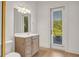Bright bathroom with a door to a balcony, modern vanity, large mirror, and neutral tile flooring at 535 Waters Way, Fayetteville, GA 30215