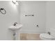 Simple bathroom featuring a pedestal sink, toilet, and minimalist fixtures in a bright white setting at 535 Waters Way, Fayetteville, GA 30215
