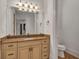 Bathroom vanity with neutral cabinets, granite countertop and large framed mirror at 535 Waters Way, Fayetteville, GA 30215
