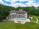 Aerial view of the home's rear exterior with pool, hot tub, and multi-level balconies, and manicured yard at 535 Waters Way, Fayetteville, GA 30215
