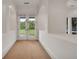 Hallway featuring neutral carpet, french doors to a balcony, and views of the landscaped yard at 535 Waters Way, Fayetteville, GA 30215