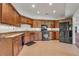 Traditional kitchen with wood cabinets, tile floors, and modern black appliances at 535 Waters Way, Fayetteville, GA 30215