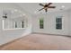 Spacious main bedroom with a ceiling fan, neutral carpet, multiple windows, and an arched mirror feature wall at 535 Waters Way, Fayetteville, GA 30215