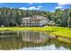 A large pond reflecting the image of a grand home with balconies and lush greenery at 535 Waters Way, Fayetteville, GA 30215