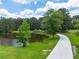 Picturesque view of the beautiful pond surrounded by mature trees and lush greenery at 535 Waters Way, Fayetteville, GA 30215