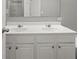 Bathroom with double sinks, white cabinetry, and a large mirror at 747 Crestwell Sw Cir, Atlanta, GA 30331
