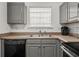 Kitchen area with stainless steel sink and dark appliances set against light countertops and grey cabinetry at 747 Crestwell Sw Cir, Atlanta, GA 30331
