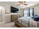Bedroom features a bed, ceiling fan, closet, dresser, TV and a large window at 1310 Speckle Park Way, Stockbridge, GA 30281