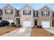 Charming townhome featuring a brick facade, a one-car garage, and manicured landscaping at 1310 Speckle Park Way, Stockbridge, GA 30281