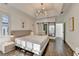 A spacious main bedroom with hardwood floors, trey ceilings, and a view of the ensuite bath at 3355 Olivia Ct, Cumming, GA 30041