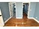 Bedroom with hardwood floors and blue walls, showing doorways to other rooms at 356 Greenwood Nw Dr, Lilburn, GA 30047