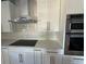 Close-up of kitchen featuring white cabinets, stainless steel appliances, and a white tile backsplash at 356 Greenwood Nw Dr, Lilburn, GA 30047