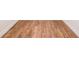 Close-up of beautiful, light-brown hardwood flooring in a well-lit room with white trim at 5410 Crow Dr, Cumming, GA 30041