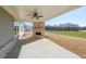 Covered patio with a brick fireplace, ceiling fan, and views of a grassy lawn at 5410 Crow Dr, Cumming, GA 30041