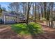 Spacious backyard offers a treed backdrop, lush lawn and a view of the home's back facade at 181 Arrowood Ln, Alpharetta, GA 30009