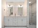 Modern bathroom features a double vanity with stone counters, tiled walls, and glass enclosed shower at 181 Arrowood Ln, Alpharetta, GA 30009