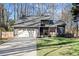 Charming home featuring a gray exterior, manicured lawn, two-car garage, and inviting front porch at 181 Arrowood Ln, Alpharetta, GA 30009