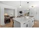 Bright kitchen island with pendant lights adjacent to a beautifully decorated and cozy living room at 181 Arrowood Ln, Alpharetta, GA 30009