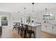 Light filled kitchen features white cabinets, an expansive island with seating, and wood flooring at 181 Arrowood Ln, Alpharetta, GA 30009
