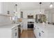 Well-lit kitchen boasts white cabinetry, stainless steel appliances, marble countertops, and modern tile backsplash at 181 Arrowood Ln, Alpharetta, GA 30009