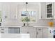 Modern kitchen featuring white cabinets, stainless steel appliances, quartz countertops, and natural light at 181 Arrowood Ln, Alpharetta, GA 30009