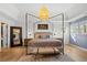 Luxurious main bedroom with a four-poster bed, stylish lighting, and hardwood floors at 181 Arrowood Ln, Alpharetta, GA 30009