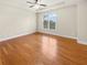 Bedroom boasts gleaming hardwood floors, a tray ceiling with ceiling fan, and a large window at 789 Liberty Commons Nw Dr, Atlanta, GA 30314