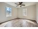 Bright bedroom featuring wood-look flooring, fan, and ample natural light streaming through two windows at 115 Bruce Rd, Douglasville, GA 30134