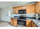 Functional kitchen with wood cabinets, black countertops, and stainless steel appliances at 115 Bruce Rd, Douglasville, GA 30134