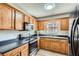 Kitchen features oak cabinets, black countertop, and stainless steel appliances, offering a functional cooking space at 115 Bruce Rd, Douglasville, GA 30134