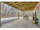 Covered patio featuring wooden beams, an outdoor table set, and a view into the wooded backyard at 115 Bruce Rd, Douglasville, GA 30134