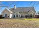 View of back exterior featuring large windows, neutral siding, and a well-maintained yard at 155 Rose Creek Dr, Covington, GA 30014