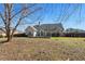 View of back exterior with large windows, neutral siding and a well-maintained lawn at 155 Rose Creek Dr, Covington, GA 30014