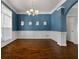 Elegant dining room with blue walls, white wainscoting, hardwood floors, and a chandelier at 155 Rose Creek Dr, Covington, GA 30014