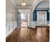 Welcoming foyer featuring hardwood floors, wainscoting, and an arched entry to the dining room at 155 Rose Creek Dr, Covington, GA 30014