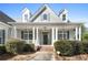 Inviting front porch with white columns, decorative lighting, and manicured shrubbery enhancing curb appeal at 155 Rose Creek Dr, Covington, GA 30014