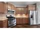 Spacious kitchen with stainless appliances, stone countertops and wood cabinets at 155 Rose Creek Dr, Covington, GA 30014