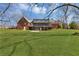 View of home's back exterior and yard featuring mature trees and green grass at 545 Highway 155 N, Mcdonough, GA 30253