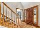 Inviting foyer with hardwood floors, wooden staircase, and glass-paneled front door at 545 Highway 155 N, Mcdonough, GA 30253