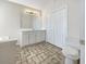 A bright bathroom featuring a large vanity, mirror, and tub with tile floors at 63 Avery Way, Dallas, GA 30157