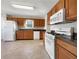 Spacious kitchen featuring wood cabinets, white appliances, and ample counter space for meal preparation at 63 Avery Way, Dallas, GA 30157