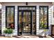 Stylish black framed back door and sidelights surrounded by planters and light-colored siding at 9465 Mistwater Close, Roswell, GA 30076